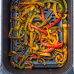 Air fryer peppers in an air fryer basket.