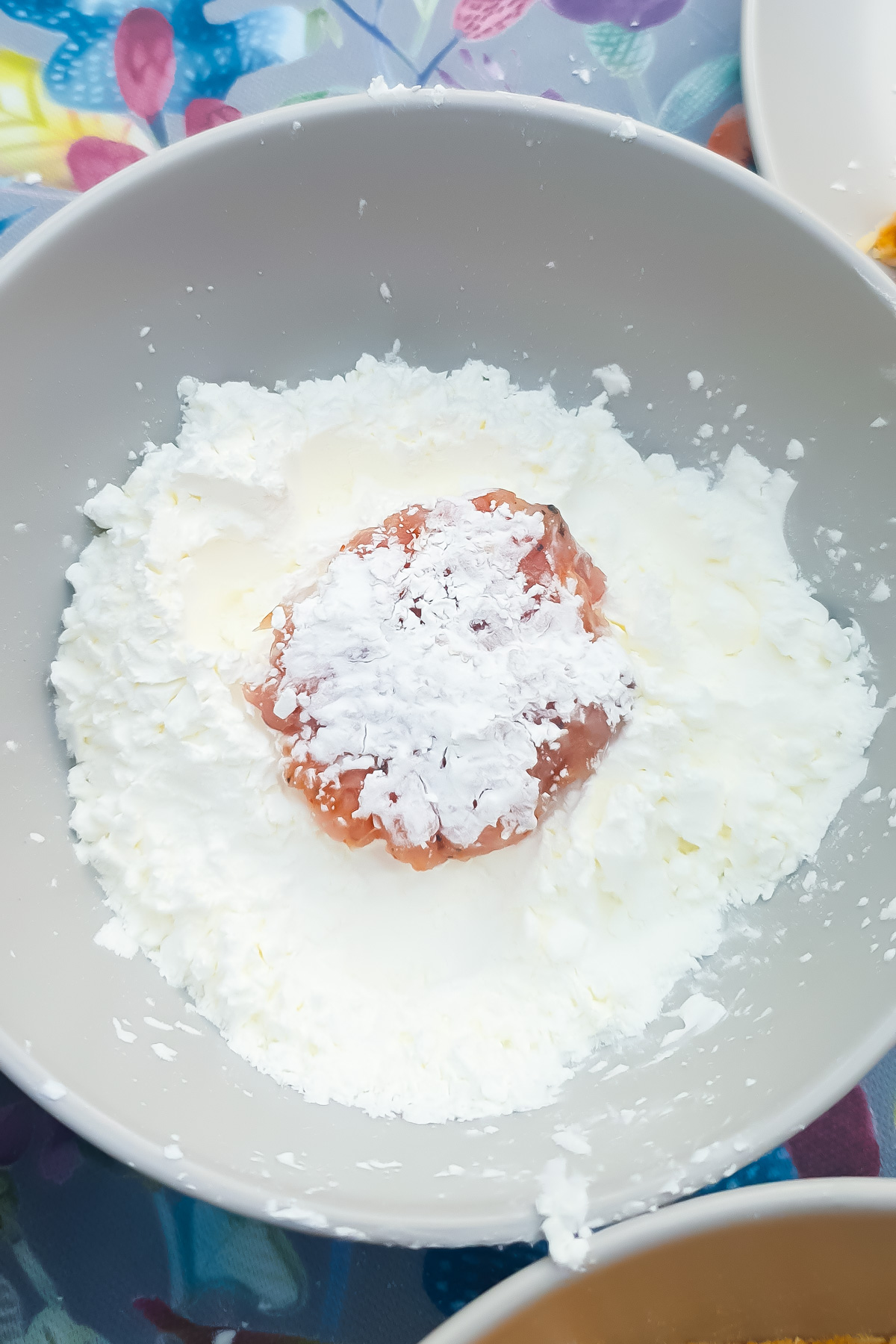 A bowl containing a ground chicken patty and cornstarch.