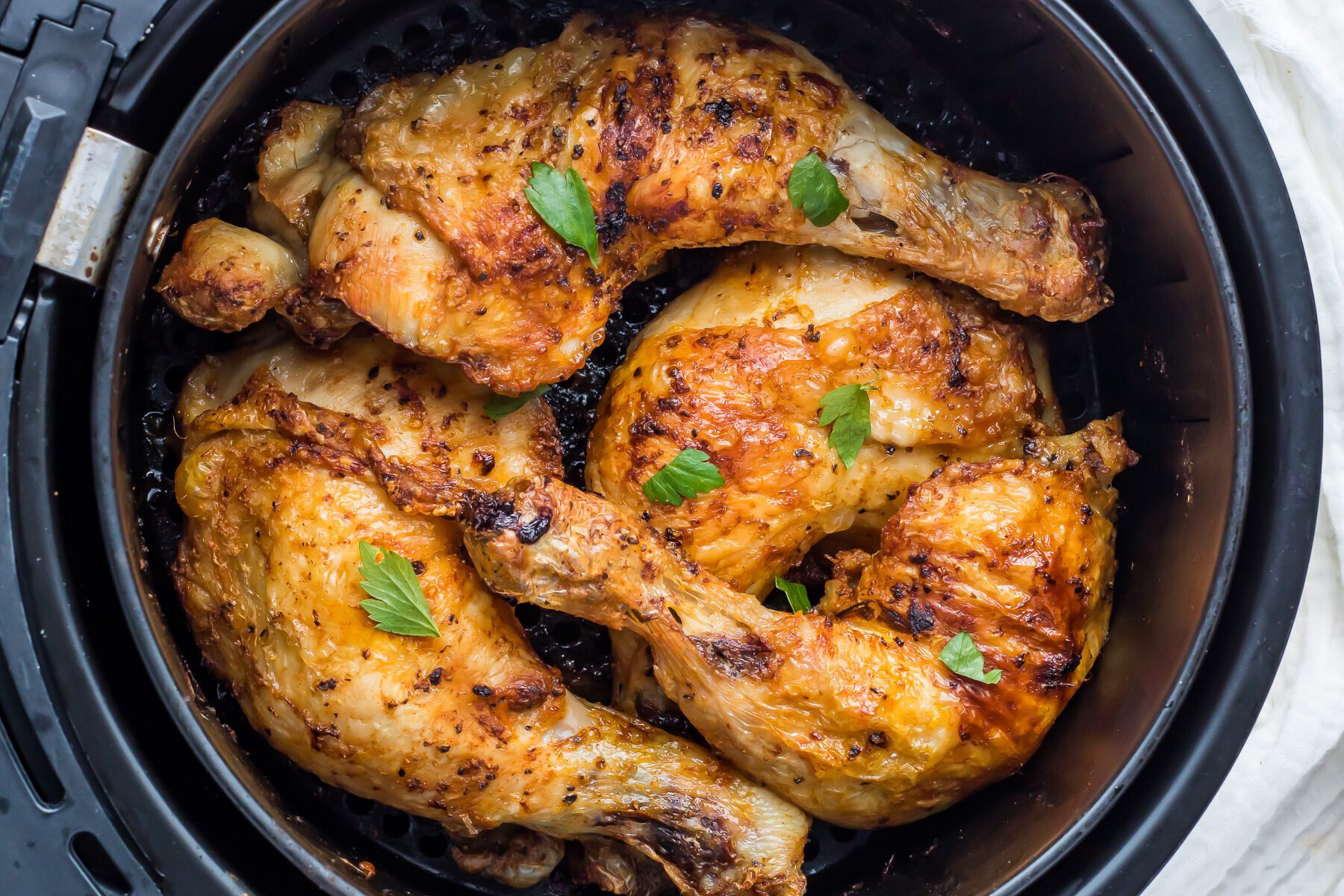 Air Fryer Chicken legs in an air fryer basket.