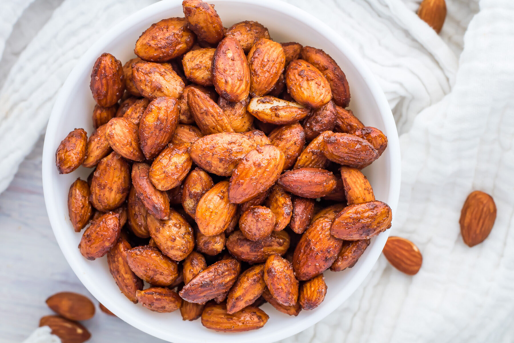 Roasted cinnamon almonds in a white bowl.