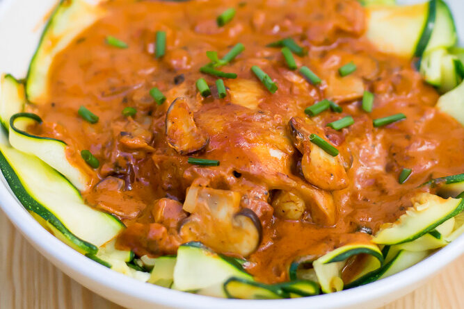 A bowl of food on a table next to a pan.