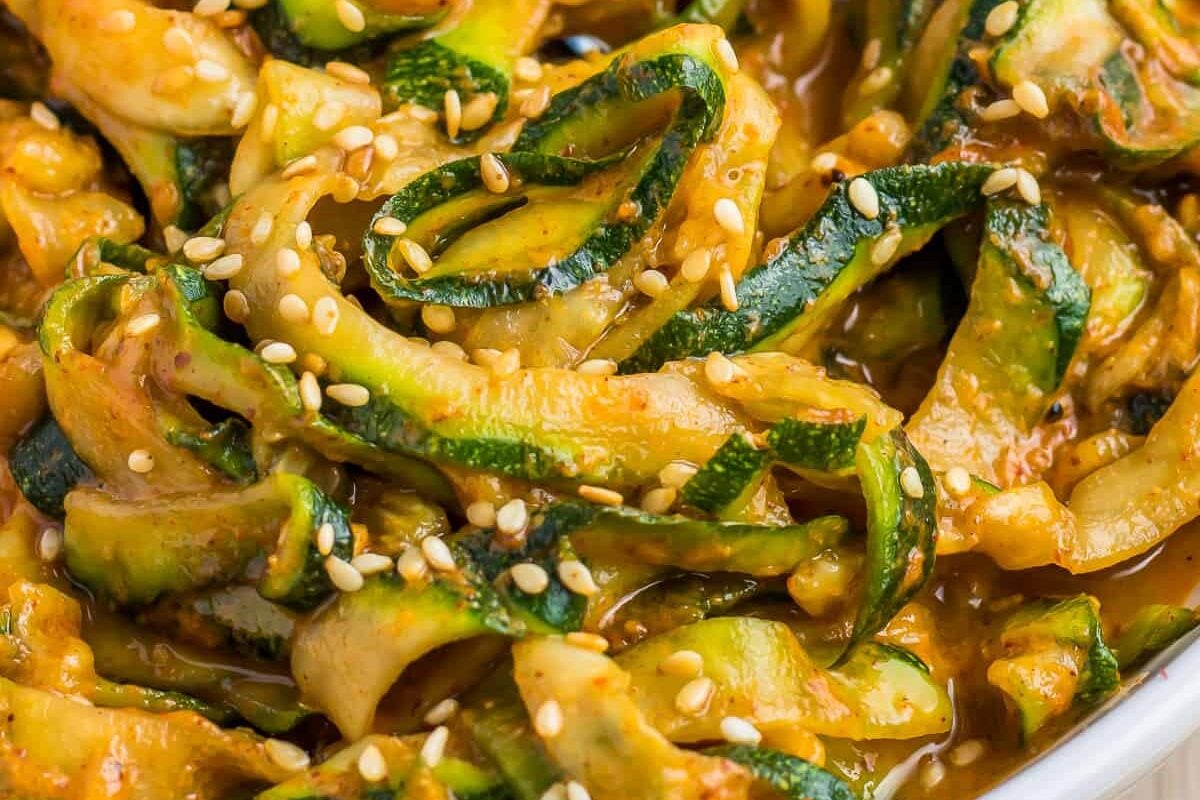 A bowl of Chinese zucchini noodles with sesame seeds.