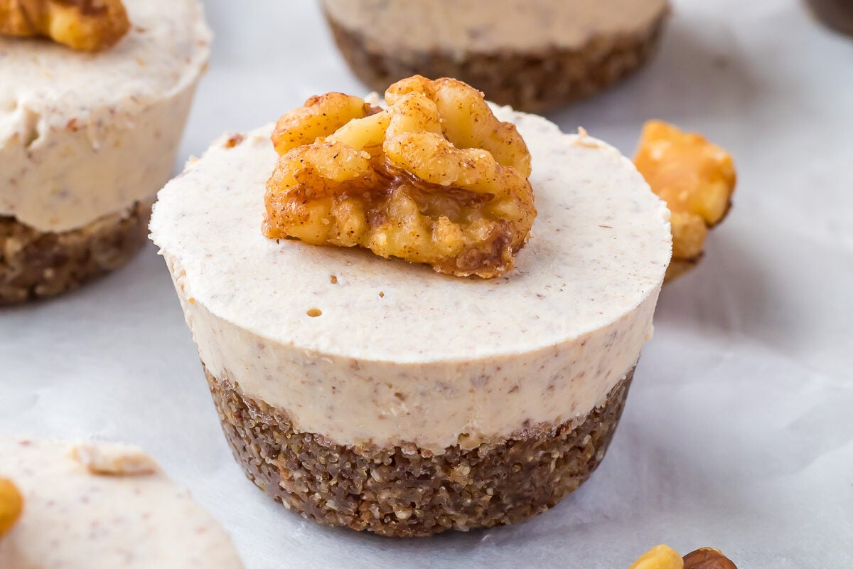 No Bake Pumpkin Cheesecake bites on parchment paper with a candied walnut on top.