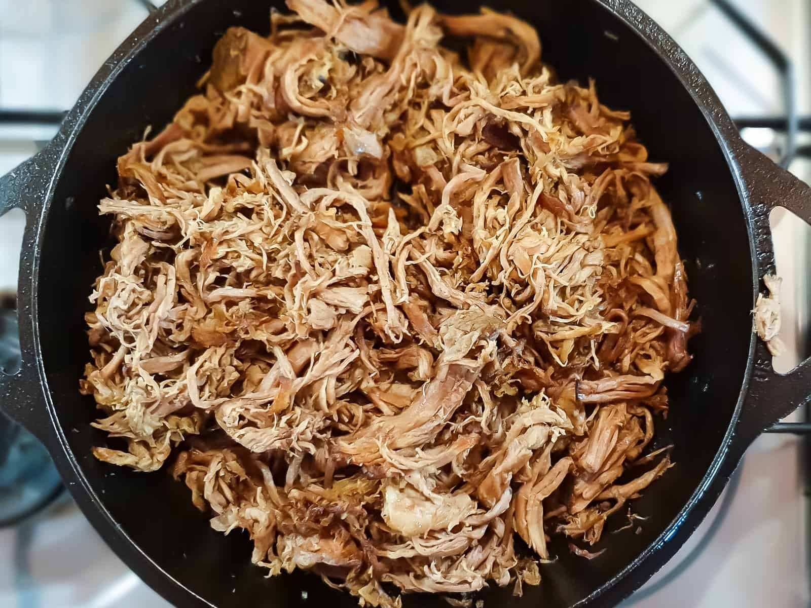 Overhead shot of paleo carnitas in a cast iron skillet.