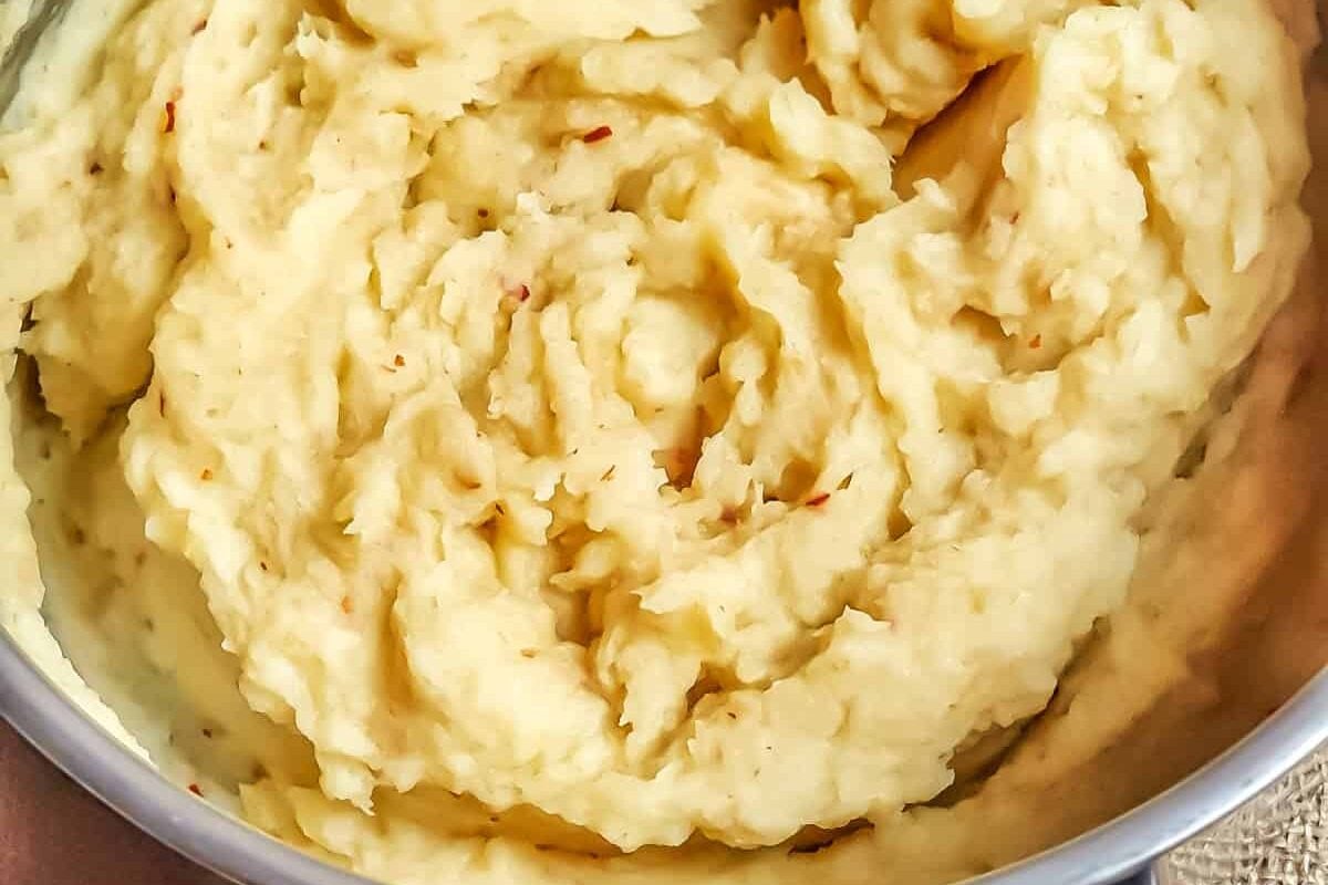 Parsnip and chili puree in stainless Steel pot on brown cloth