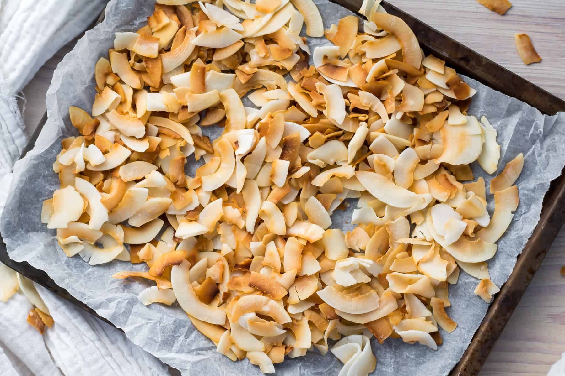 Toasted coconut flakes on a baking sheet.