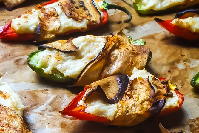 A group of stuffed peppers on a baking sheet.