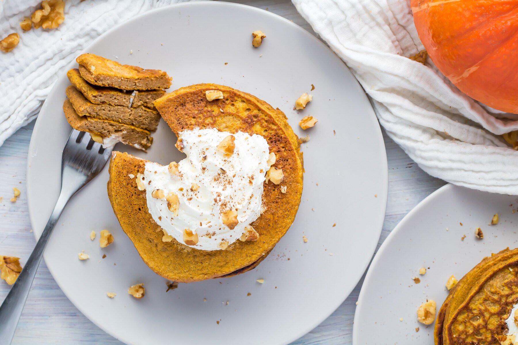 Whole30 pumpkin pancakes with whipped cream and walnuts.
