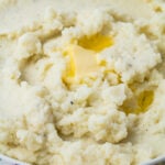 A bowl of cauliflower mash with a pat of melting butter on top.