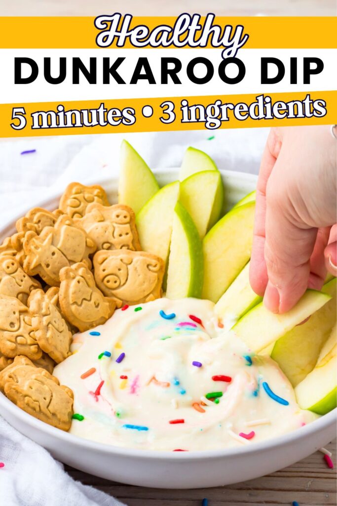 A bowl with animal cookies, apple slices, sprinkle-topped healthy dunkaroo dip, and a hand dipping an apple slice into the dip; text reads “Healthy Dunkaroo Dip, 5 minutes, 3 ingredients.”.