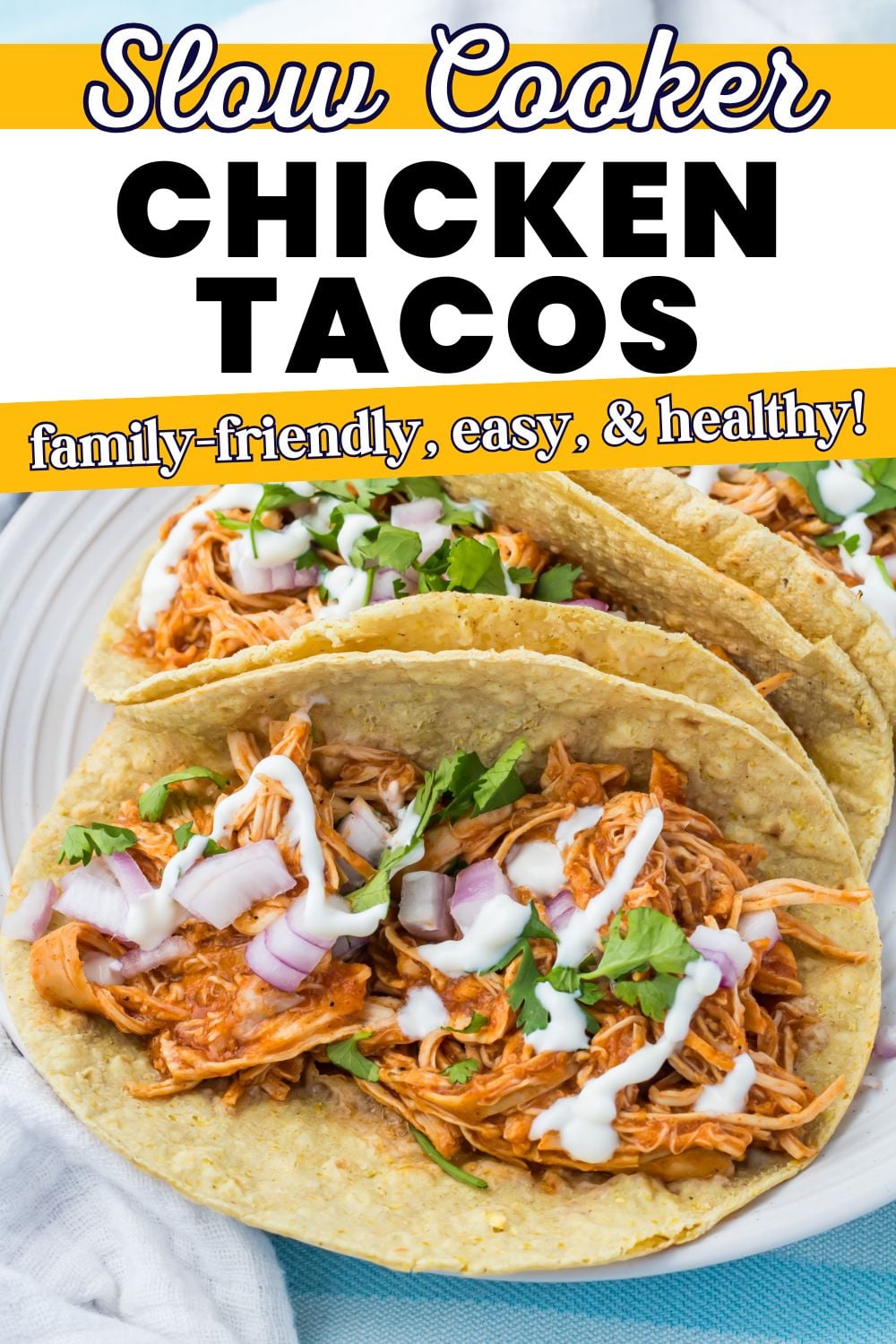 Three shredded chicken tacos topped with chopped red onion, cilantro, and a drizzle of white sauce on corn tortillas, served on a plate. Text overlay describes slow cooker chicken tacos.