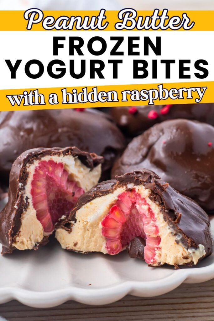 Chocolate-coated frozen yogurt bites cut in half, revealing a raspberry center, displayed on a white plate with more bites in the background.